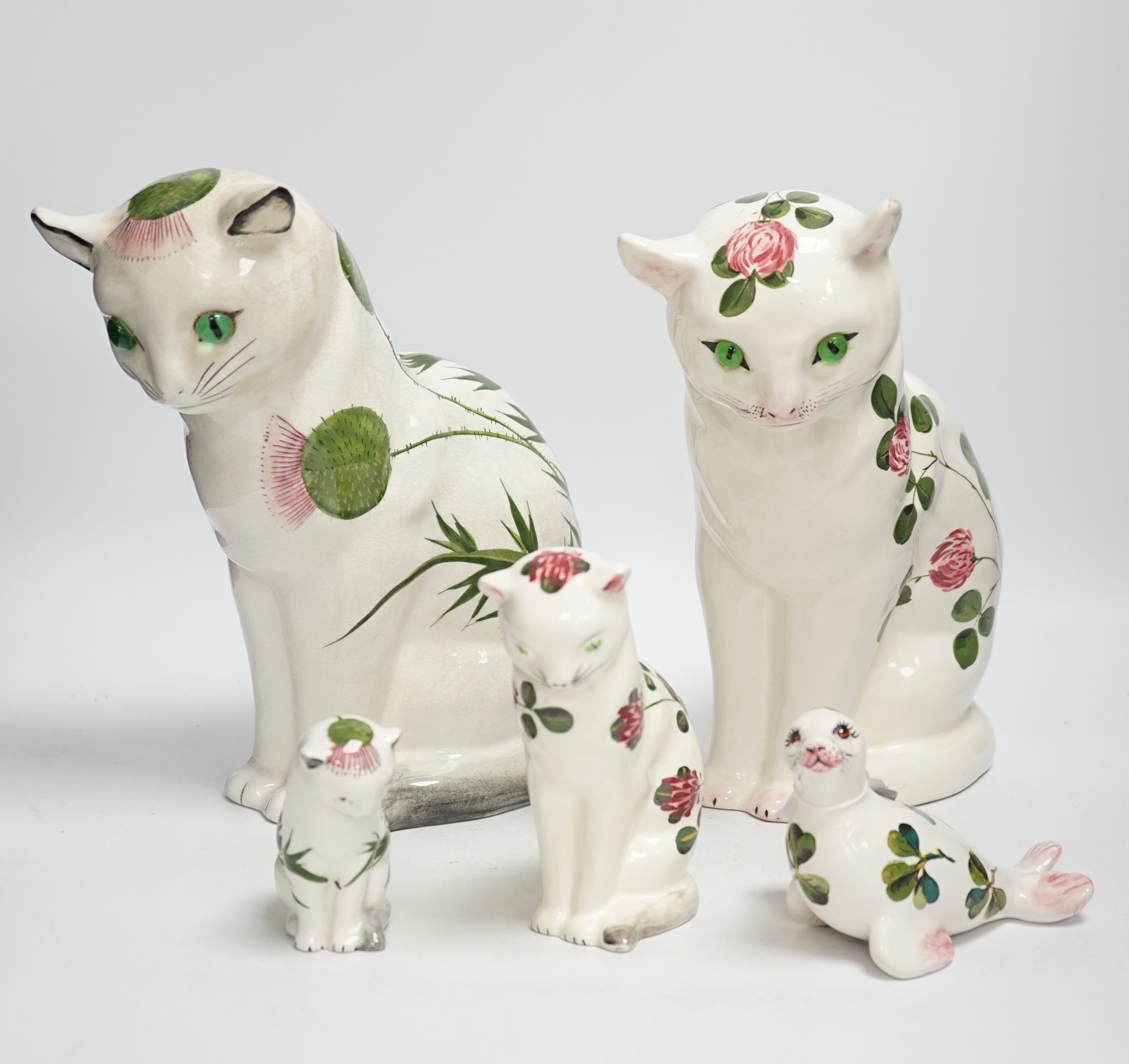 A Plichta clover pattern cat, a Plichta thistle pattern cat, together with two small Plichta cats and a seal, largest 26cm high